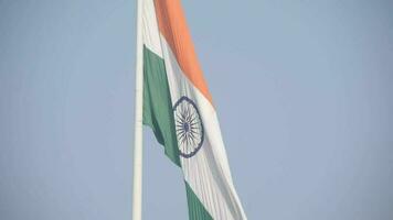 India flag flying high at Connaught Place with pride in blue sky, India flag fluttering, Indian Flag on Independence Day and Republic Day of India, tilt up shot, Waving Indian flag, Har Ghar Tiranga video