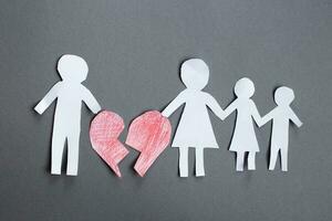 Paper chain cut family with broken heart on gray background. Divorce and broken family concept photo