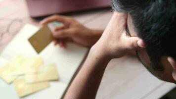 Upset young man hand holding credit card on table video