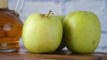 appelazijn in glazen fles met verse groene appel op tafel video