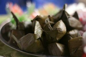 lemper, a traditional snack from Indonesia made of glutinous rice with shredded beef filling, selective focus at the place of celebration. photo