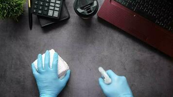 hand in blauwe rubberen handschoenen met spuitfles reinigingstafel video