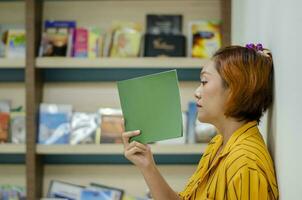 joven mujer en pie y leyendo en el biblioteca foto