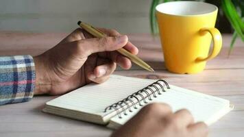 Cerca de la mano del hombre escribiendo en el bloc de notas video