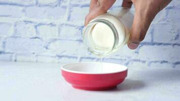 Pouring coconut coins in a container on table video