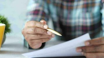 Mens hand- met pen analyseren financieel tabel Aan papier video