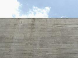 grey concrete wall over blue sky background photo