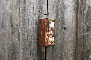 Old rusty hinge on a wooden door. Old rustic background photo