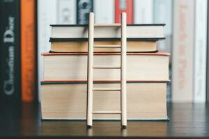 A studying climbing up to the book stack. A concept of education process. Copy space for text. Distance education, e-learning concept. scale that reaches knowledge and freedom. photo