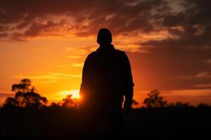 el silueta de un joven hombre en contra el antecedentes de el calor de un dorado atardecer, un hermosa ver de el cielo generativo ai foto