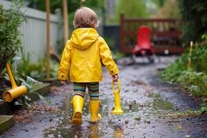 child in the rain in a rain yellow suit photo