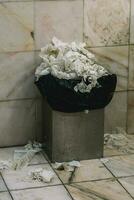 Bucket full of paper towels in a WC photo