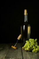 Glass bottle of wine with corks on wooden table background photo