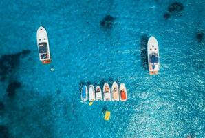 Aerial view of luxury yachts and boats on blue sea at sunset photo