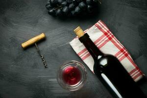 Glass bottle of wine with corks on wooden table background photo