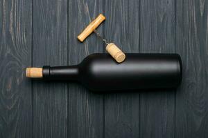 Glass bottle of wine with corks on wooden table background photo