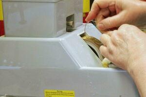 Factory for making spectacle lenses and frames, myopia glasses, production line. Close-up hands of a master polishing glasses in salon of optical shop. photo