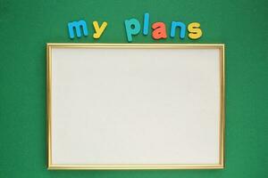 Colorful alphabet word text My plans and blank frame on green background. photo