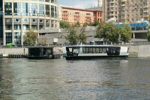 Aquabus boat on Moskva River. Electrical ship at Moscow public transport. Ecological technology. Green energy in city route. Daily passenger ferry service. Moscow, Russia - June 22, 2023. photo