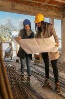 Architecture, Women with hard hat, working on the construction of a building working in a team and blueprint reading. photo