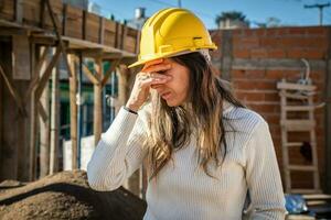 retrato de preocupado o cansado mujer arquitecto a un construcción sitio. foto