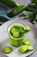 Diet cucumber and mint smoothie in a glass for breakfast vertical view photo