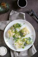 Vegetarian spring rolls with three types of cabbage in rice paper on a plate top and vertical view photo