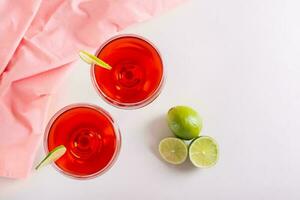 Cosmopolitan cocktail with lime in glasses on the table top view photo