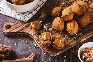 Fresh nut shaped cookies filled with boiled condensed milk on a board photo
