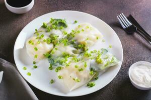 Vegetarian spring rolls with three types of cabbage in rice paper on a plate photo