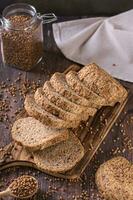 Pieces of homemade buckwheat bread on a cutting board on the table vertical view photo