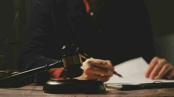 Justice and law concept.Male judge in a courtroom with the gavel, working with, computer and docking keyboard, eyeglasses, on table in morning light video