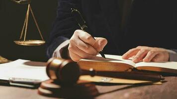 Justice and law concept.Male judge in a courtroom with the gavel, working with, computer and docking keyboard, eyeglasses, on table in morning light video