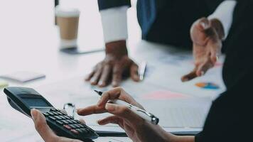 financiële analisten analyseren zakelijke financiële rapporten over een investeringsproject voor digitale tabletplanning tijdens een discussie op een bijeenkomst van bedrijven die de resultaten van hun succesvolle teamwerk laten zien. video