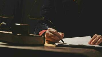 Justice and law concept.Male judge in a courtroom with the gavel, working with, computer and docking keyboard, eyeglasses, on table in morning light video