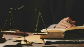 Justice and law concept.Male judge in a courtroom with the gavel, working with, computer and docking keyboard, eyeglasses, on table in morning light video