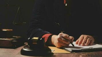 concept de justice et de droit. juge masculin dans une salle d'audience avec le marteau, travaillant avec, clavier d'ordinateur et d'accueil, lunettes, sur table à la lumière du matin video