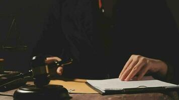 concepto de justicia y derecho. juez masculino en una sala de audiencias con el mazo, trabajando con computadora y teclado de acoplamiento, anteojos, en la mesa a la luz de la mañana video