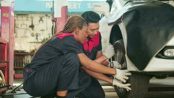 professionnel asiatique Masculin automobile superviseur qualifié mécanicien technicien à vis voiture roue des noisettes avec clé pour réparation à garage, véhicule entretien un service travaux industrie Occupation affaires emplois. video