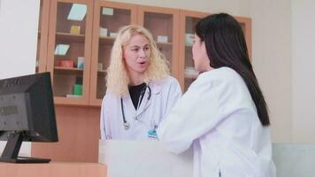 Due professionale medico personale, asiatico femmina medico, e bianca farmacista discusso trattamento medicina prescrizioni a contatore di il farmacia Dipartimento nel ospedale clinica. video