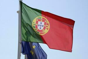 portugués nacional bandera y bandera de el europeo Unión ondulación en el viento foto