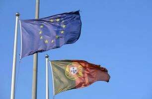 portugués nacional bandera y bandera de el europeo Unión ondulación en el viento foto