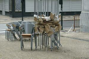 apilado sillas y mesas a un cerrado restaurante foto