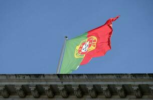 Portuguese flag waving in the wind against a clear sky photo