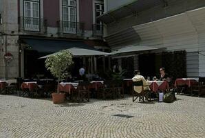 Lisboa, Portugal - mayo 20, 2023 - un Pareja se sienta en un de lo contrario vacío restaurante o café en un soleado día foto