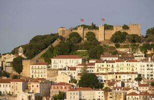 edificios y techo tapas en Lisboa en el tarde horas con el castillo en el antecedentes foto