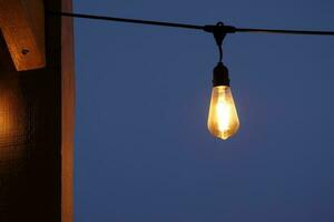 Light bulb against a dark sky at nightfall photo