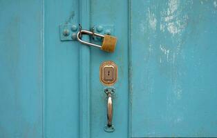 Turquoise wooden door with a padlock photo