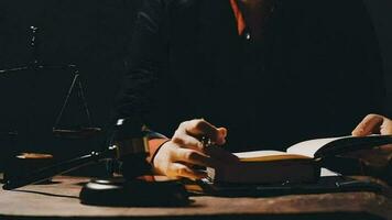 Justice and law concept.Male judge in a courtroom with the gavel, working with, computer and docking keyboard, eyeglasses, on table in morning light video