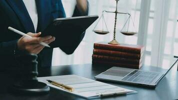 Justice and law concept.Male judge in a courtroom with the gavel, working with, computer and docking keyboard, eyeglasses, on table in morning light video